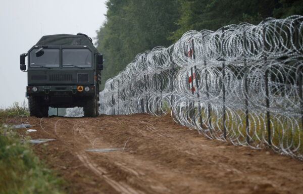 Polish soldiers build a fence on the border between Poland and Belarus near the village of Nomiki