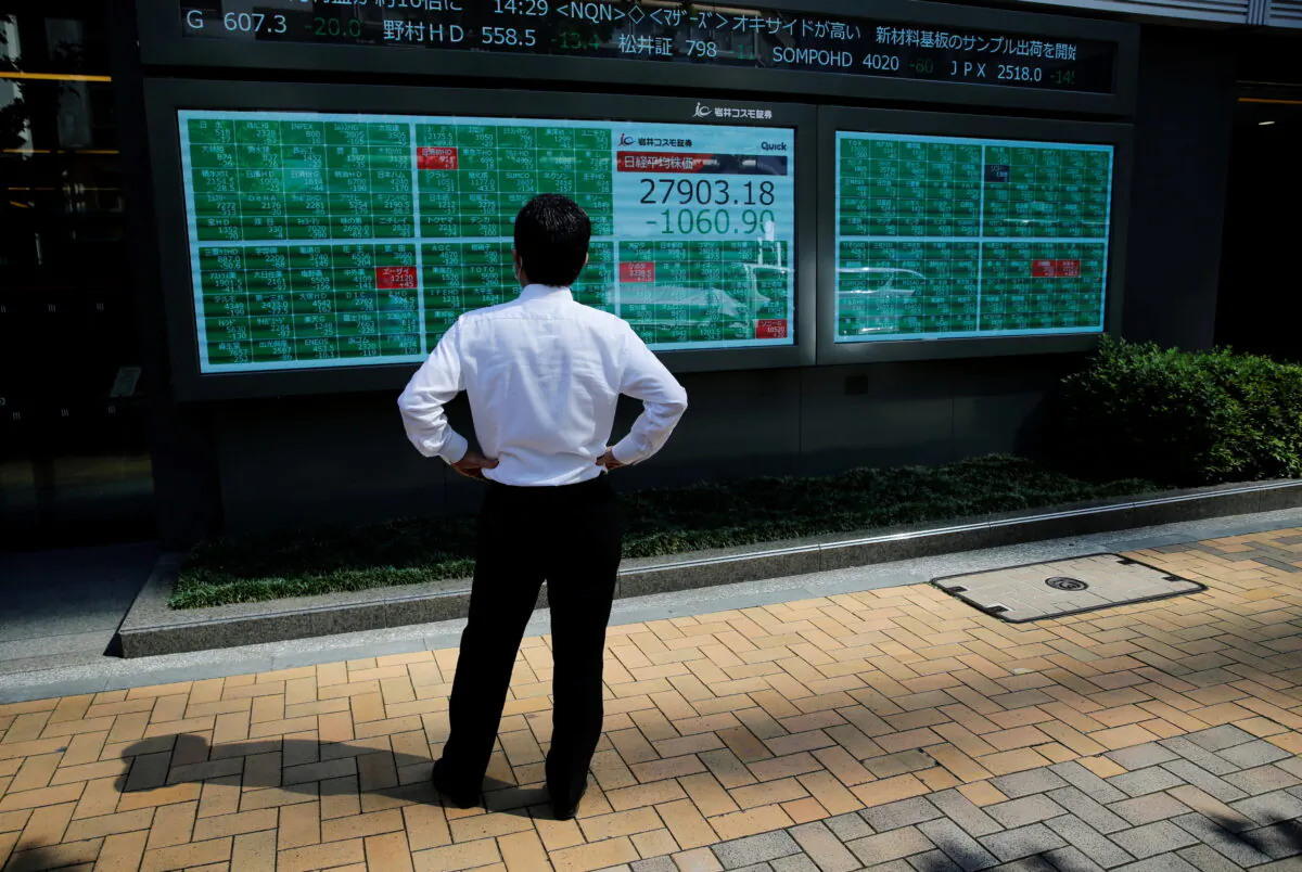 A man watches an electric board showing Nikkei index outside a brokerage at a business district in Tokyo, Japan, on June 21, 2021. (Kim Kyung-Hoon/Reuters)
