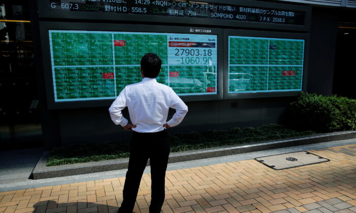 A man watches an electric board showing Nikkei index outside a brokerage at a business district in Tokyo, Japan, on June 21, 2021. (Kim Kyung-Hoon/Reuters)
