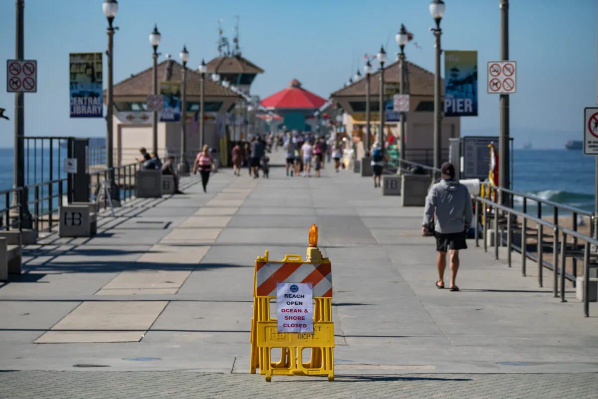 Cleanup efforts are underway in Huntington Beach, Calif., to clean a massive oil spill that struck the coastline on Oct. 3, 2021. This photo of the Huntington Beach pier was taken on Oct. 5, 2021. (John Fredricks/The Epoch Times)