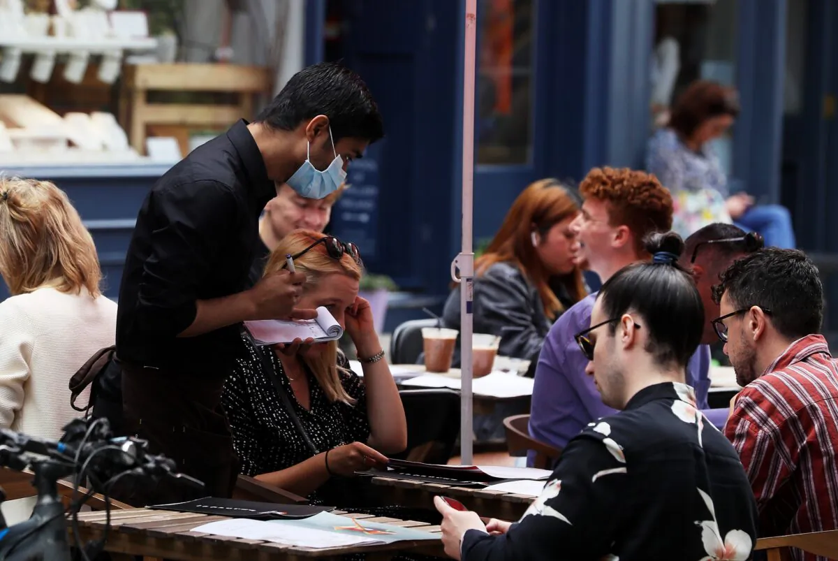 A waiter takes orders at a restaurant in Dublin's city centre on Aug. 4, 2021. (Brian Lawless/PA)