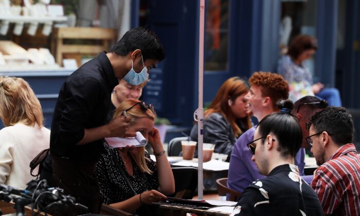 A waiter takes orders at a restaurant in Dublin's city centre on Aug. 4, 2021. (Brian Lawless/PA)