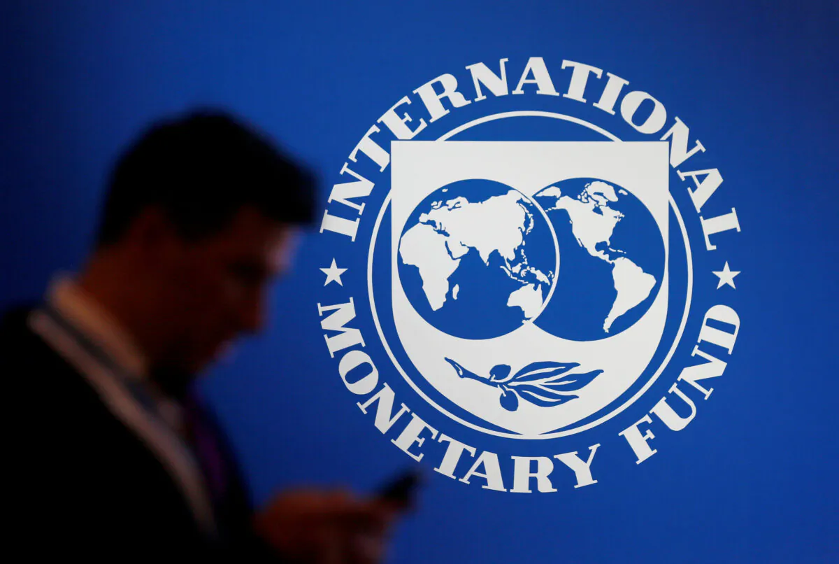 A participant stands near a logo of IMF at the International Monetary Fund/World Bank Annual Meeting in Nusa Dua, Bali, Indonesia on Oct. 12, 2018. (Johannes P. Christo/Reuters)