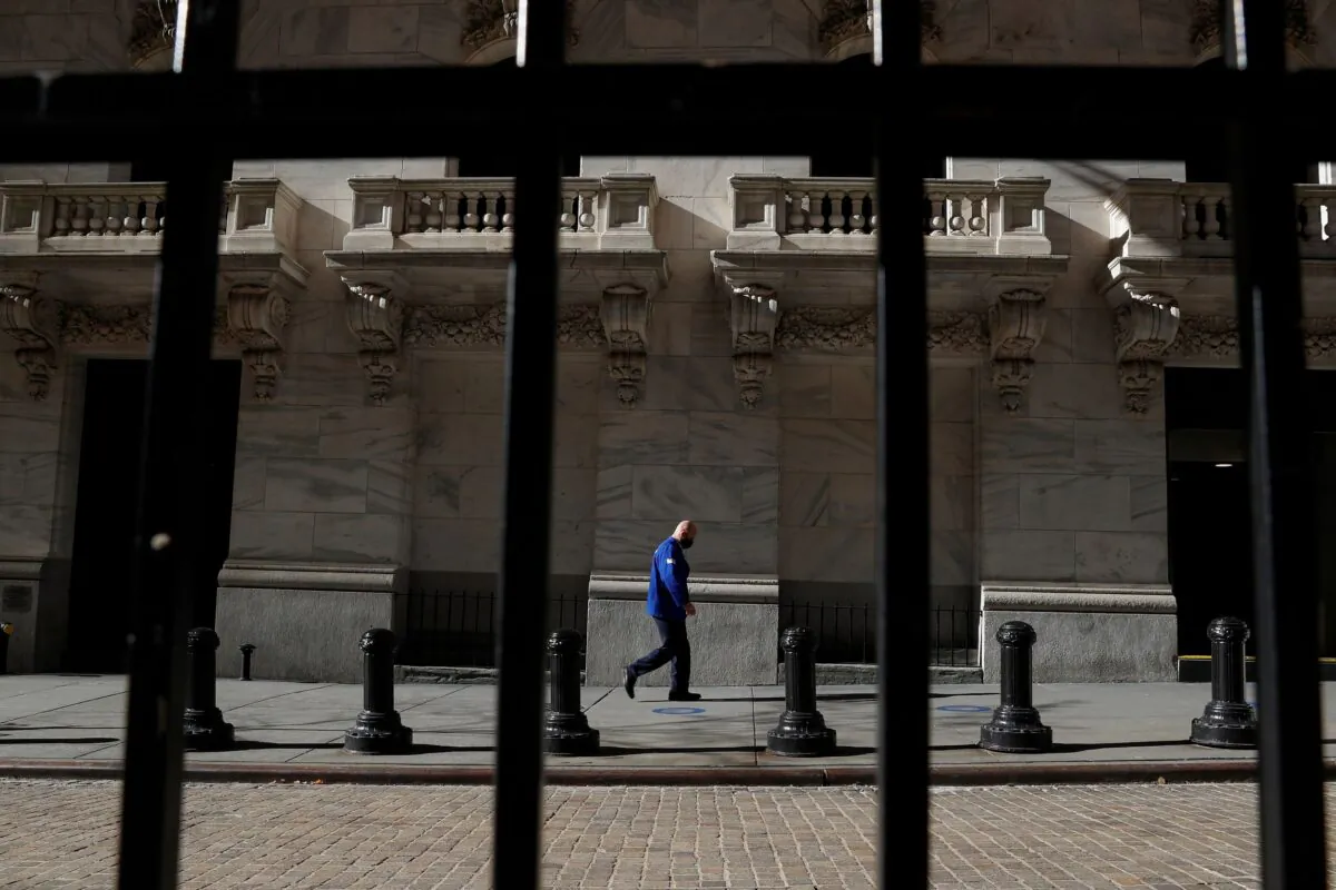 A trader wearing a protective face mask walks, as the global outbreak of the coronavirus disease (COVID-19) continues, at the New York Stock Exchange (NYSE) in the financial district of New York on Nov. 19, 2020. (Shannon Stapleton/Reuters)