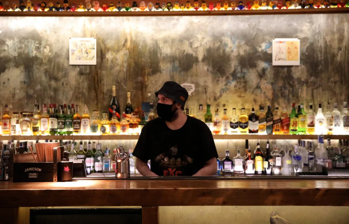 A bartender wearing a protective face mask is pictured at Bar Friday, as night clubs reopen at 50 percent capacity, following the outbreak of the COVID-19, in Sofia, Bulgaria on April 29, 2021. (Spasiyana Sergieva/Reuters)