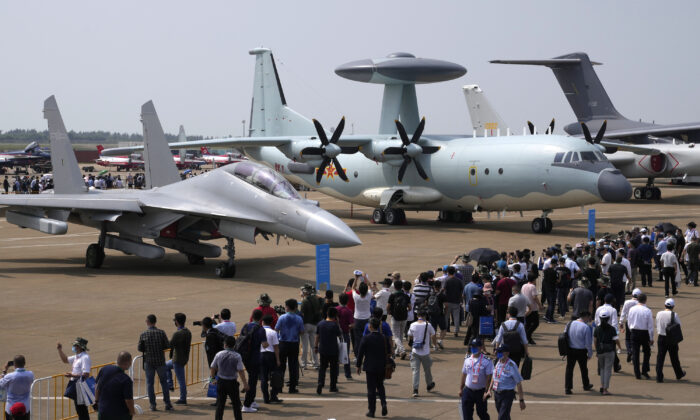 Visitors look at the Chinese military’s J-16D electronic warfare airplane (left) and the KJ-500 airborne early warning and control aircraft (right) during the 13th China International Aviation and Aerospace Exhibition in Zhuhai, Guangdong Province, China, on Sept. 29, 2021. (Ng Han Guan/AP Photo)