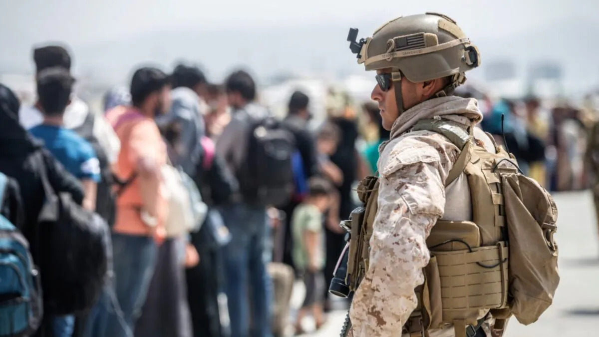 A Marine with Special Purpose Marine Air-Ground Task Force-Crisis Response-Central Command provides assistance during an evacuation at Hamid Karzai International Airport in Kabul, Afghanistan, on Aug. 22, 2021. (Sgt. Samuel Ruiz/U.S. Marine Corps via AP)