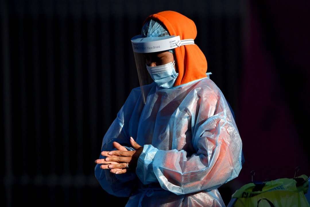 A health worker preparing to take swab samples from residents at a COVID-19 drive-through testing site in western Sydney on Aug. 4, 2021. (Saeed Khan/AFP via Getty Images)