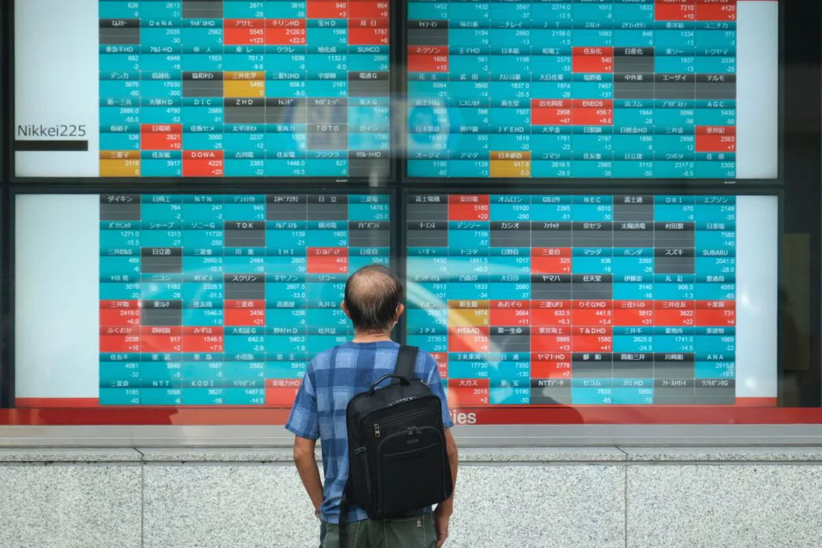 A pedestrian looks at an electronic quotation board displaying compnaies' stock prices of the Tokyo Stock Exchange in Tokyo, Japan on Oct. 5, 2021. (Kazuhiro Nogi/AFP via Getty Images)