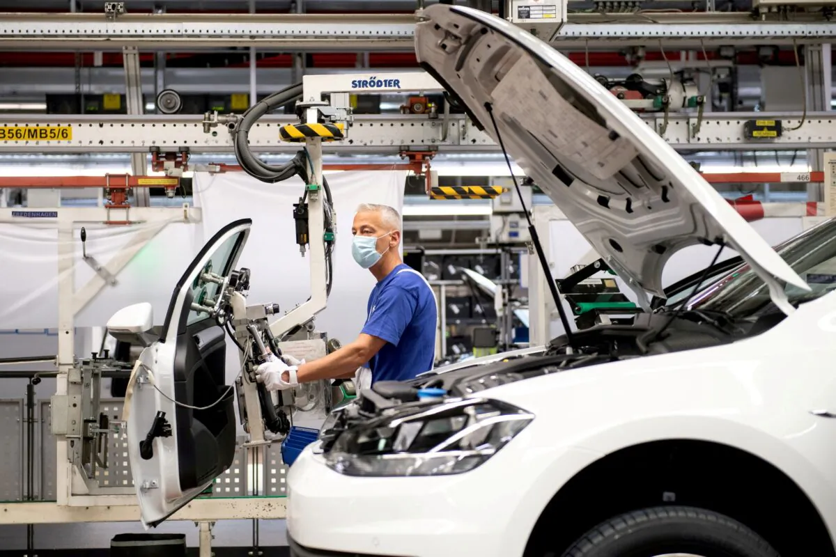 A worker wears a protective mask at the Volkswagen assembly line after VW re-starts Europe's largest car factory after coronavirus shutdown in Wolfsburg, Germany on April 27, 2020. (Swen Pfoertner/Pool via Reuters)