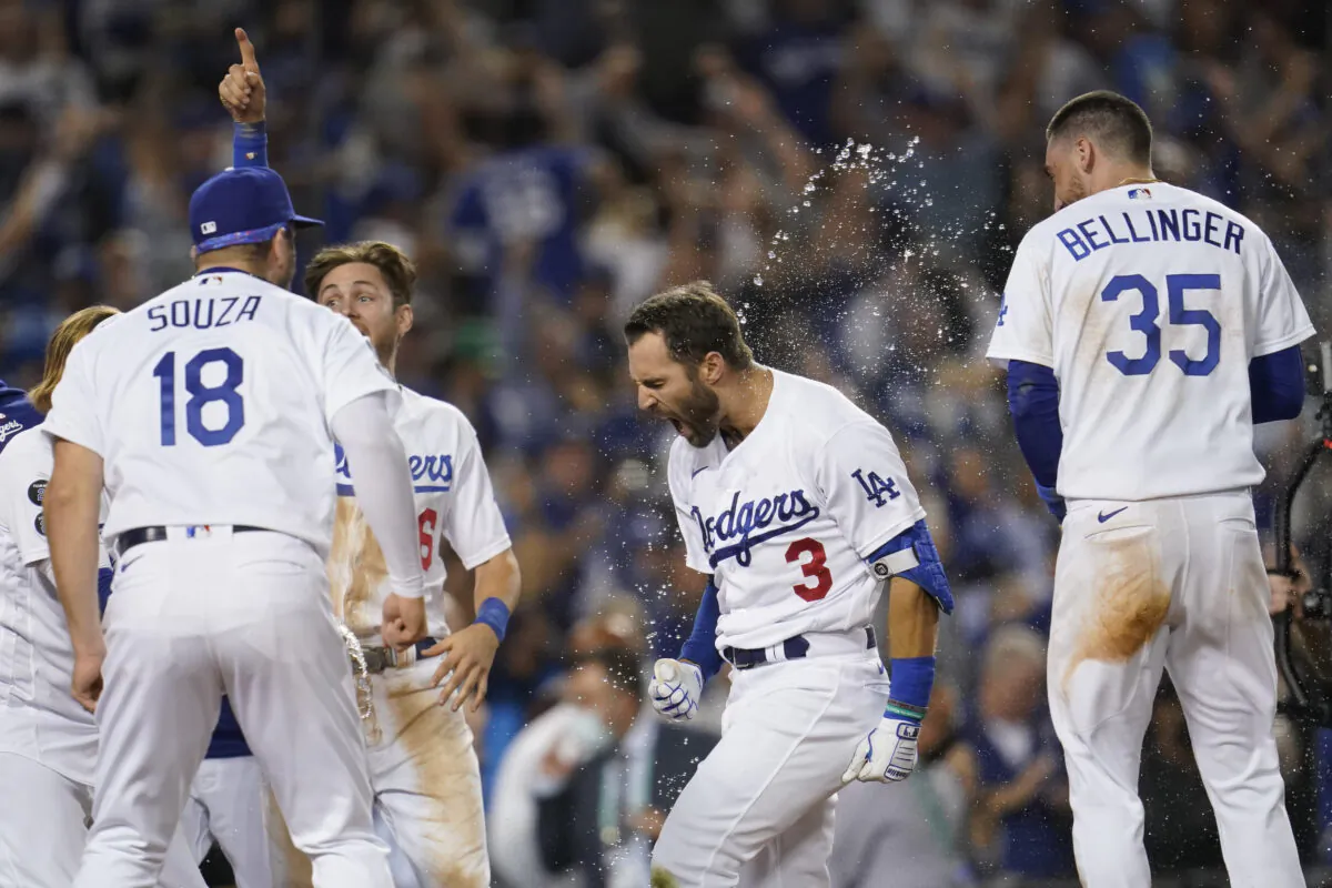 The Los Angeles Dodgers celebrate with Chris Taylor (3) after he hit a home run during the ninth inning to win a National League Wild Card playoff baseball game 3-1 over the St. Louis Cardinals in Los Angeles on Oct. 6, 2021. (AP Photo/Marcio Jose Sanchez)