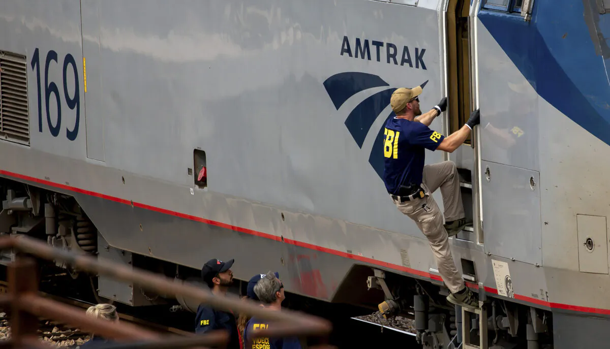 A Federal Bureau of Investigation agent boards an Amtrak train after a shooting aboard the train in downtown Tucson, Ariz. on Oct. 4, 2021. (Rebecca Sasnett/Arizona Daily Star via AP)