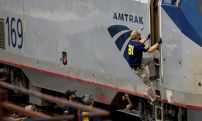A Federal Bureau of Investigation agent boards an Amtrak train after a shooting aboard the train in downtown Tucson, Ariz. on Oct. 4, 2021. (Rebecca Sasnett/Arizona Daily Star via AP)