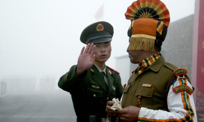 A Chinese soldier gestures as he stands near an Indian soldier on the Chinese side of the ancient Nathu La border crossing between India and China on July 10, 2008.  (DIPTENDU DUTTA/AFP via Getty Images) 