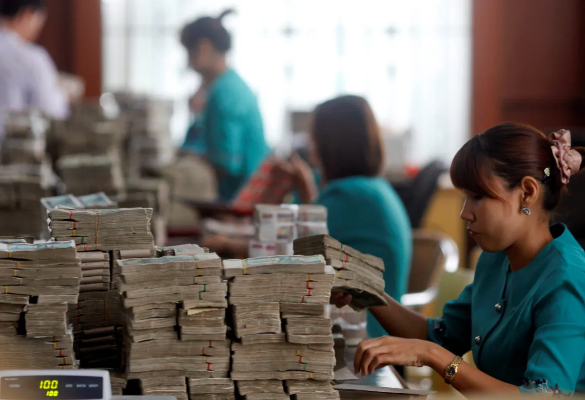 Workers count Myanmar's kyat banknotes at the office of a local bank in Yangon April 2, 2012. (Soe Zeya Tun/Reuters)