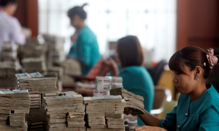 Workers count Myanmar's kyat banknotes at the office of a local bank in Yangon April 2, 2012. (Soe Zeya Tun/Reuters)