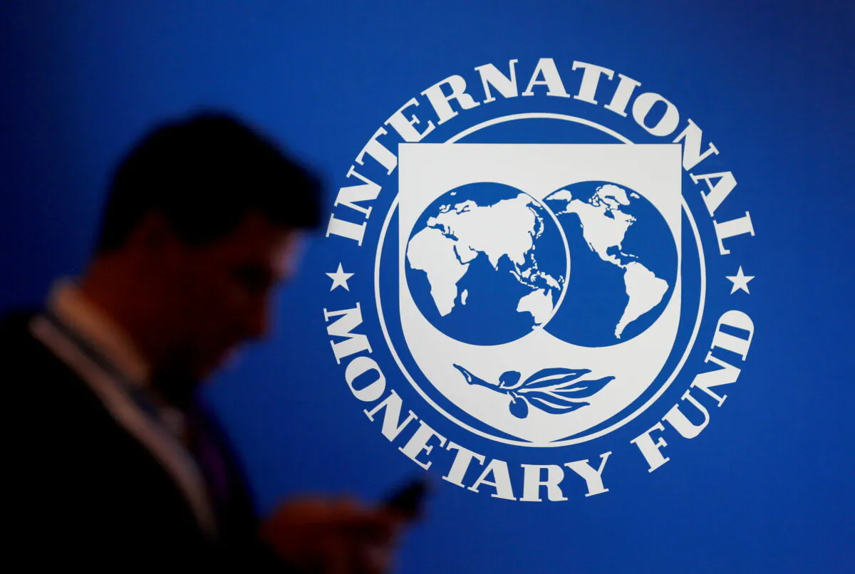 A participant stands near a logo of IMF at the International Monetary Fund - World Bank Annual Meeting 2018 in Nusa Dua, Bali, Indonesia, on Oct.12, 2018. (Johannes P. Christo/Reuters)