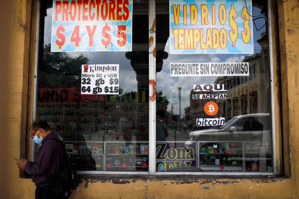A man stands by a sign that reads, "Bitcoin accepted here", outside a store where the cryptocurrency is accepted as a payment method in San Salvador, El Salvador on Sept. 24, 2021. (Jose Cabezas/Reuters)