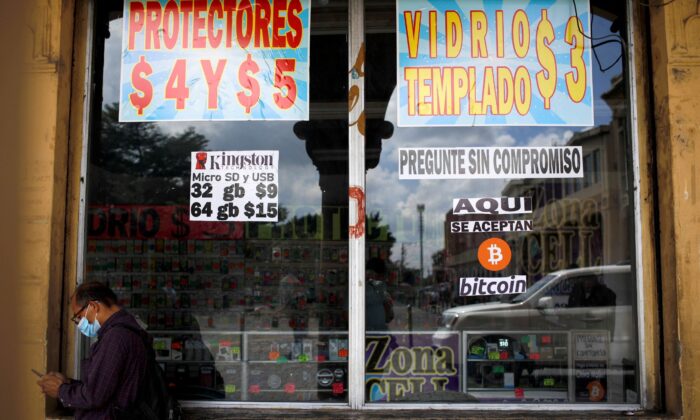 A man stands by a sign that reads, "Bitcoin accepted here", outside a store where the cryptocurrency is accepted as a payment method in San Salvador, El Salvador on Sept. 24, 2021. (Jose Cabezas/Reuters)