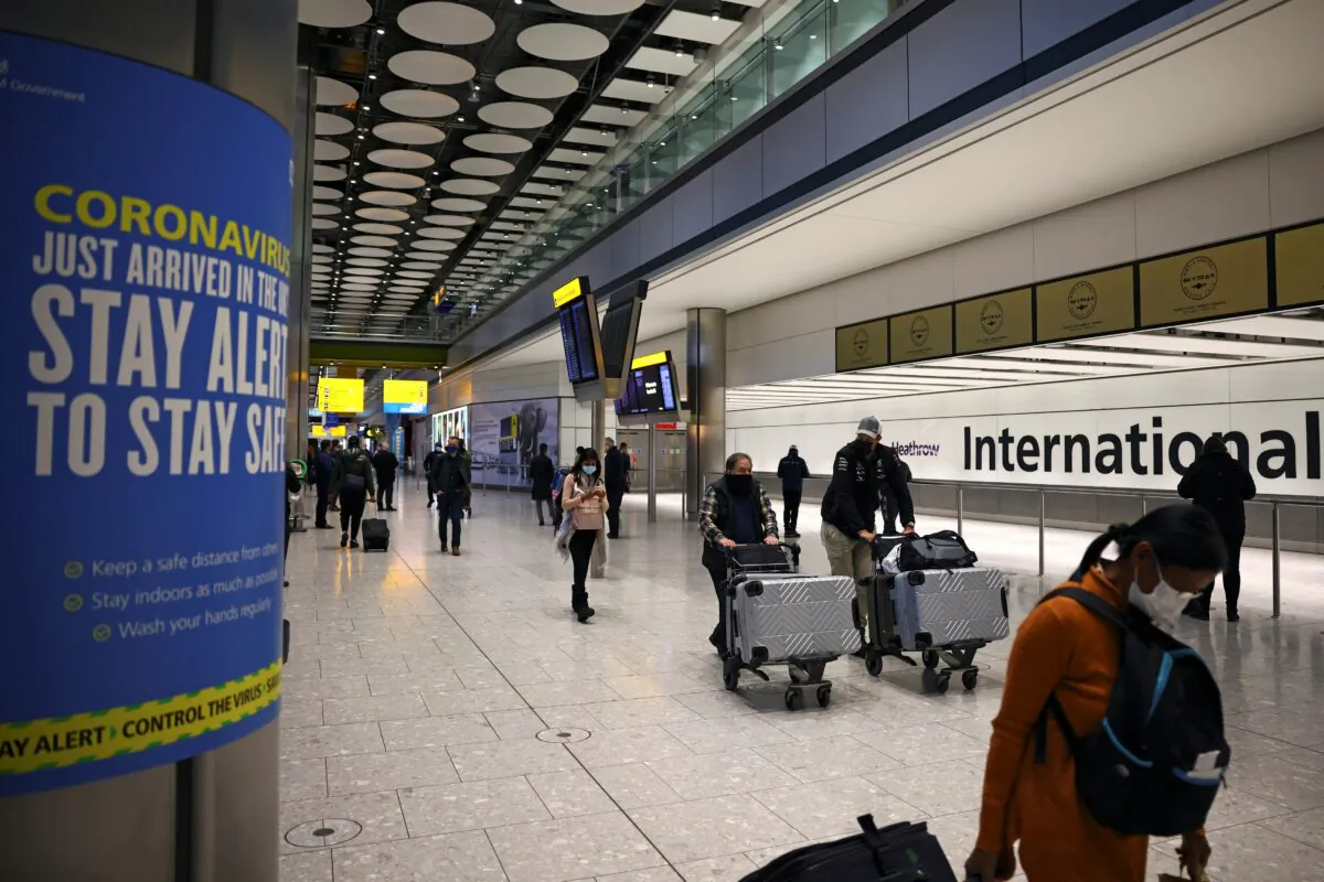 Travellers walk through the arrivals area, as tighter rules for international travellers start, at Heathrow Airport, amid the spread of the COVID-19 pandemic, London, Britain, on Jan. 18, 2021. (Henry Nicholls/Reuters)