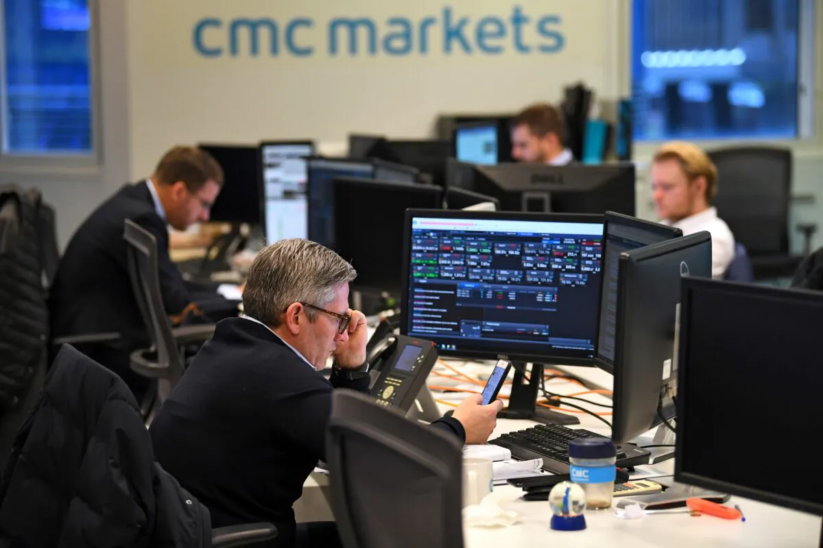 Dealers work at their desks whilst screens show market data at CMC Markets in London, Britain, Jan. 30, 2019. (Dylan Martinez/Reuters, File Photo)
