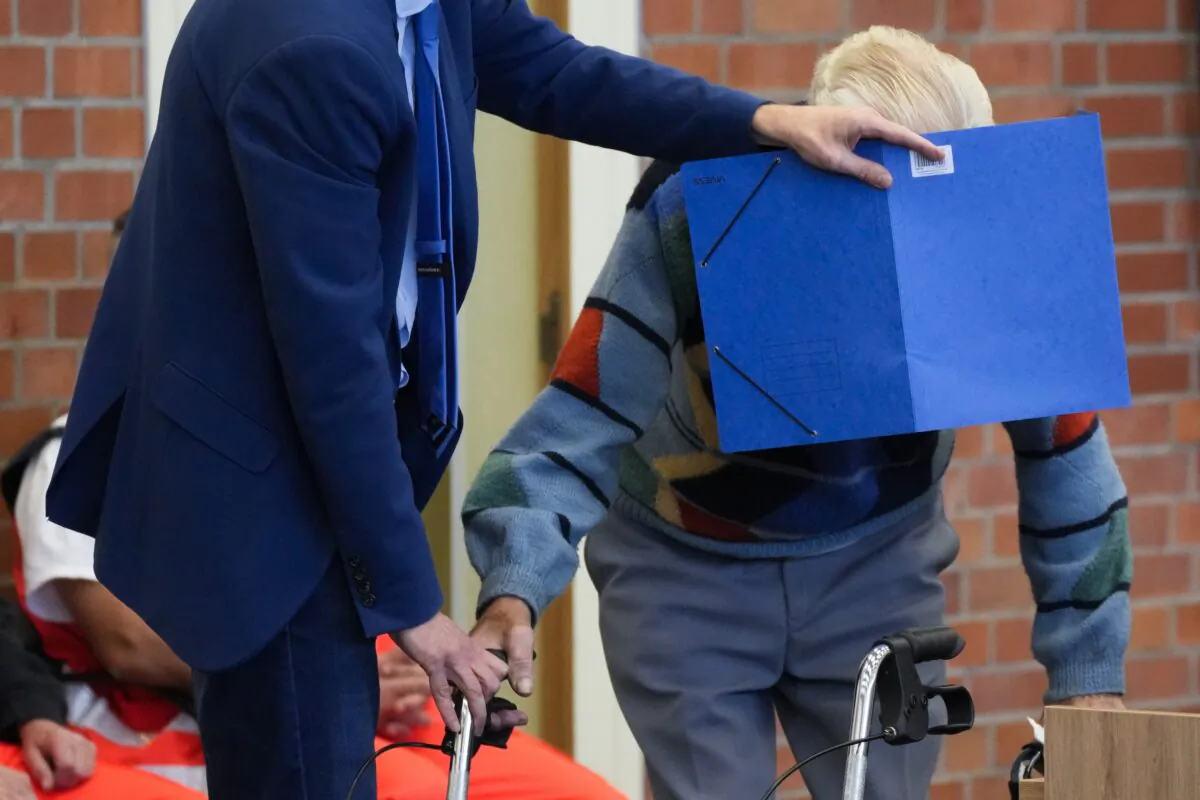 Lawyer Stefan Waterkamp covers the face of accused Josef S. as they arrive at a courtroom in Brandenburg, Germany, on Oct. 7, 2021. (Markus Schreiber/AP Photo)