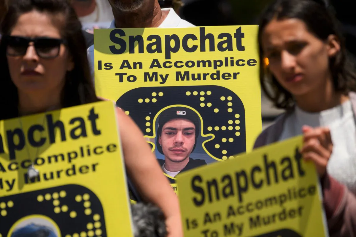 Family and friends of people who died after being poisoned by pills containing fentanyl carry signs as they protest near the Snap, Inc. headquarters, makers of the Snapchat social media application, in Santa Monica, Calif., on June 4, 2021. (Patrick T. Fallon/AFP via Getty Images)