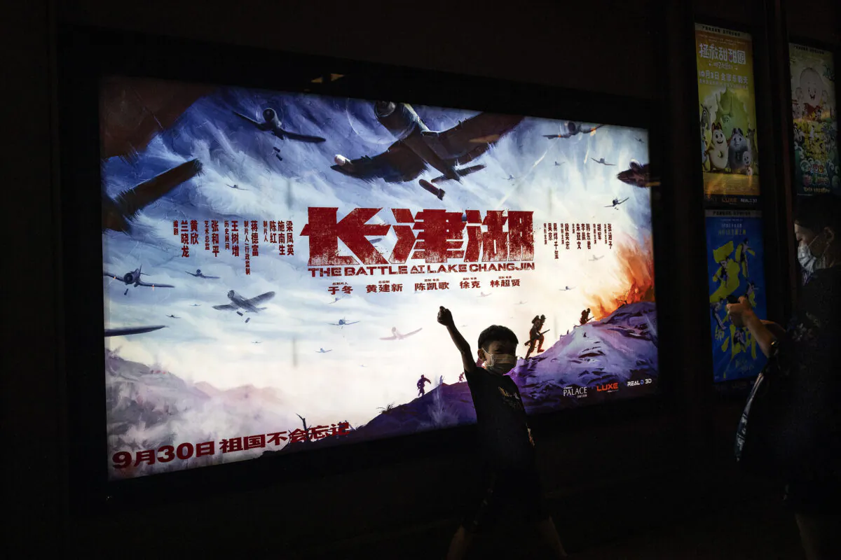 A boy poses in front of the movie poster of “The Battle At Lake Changjin" in a cinema in Wuhan, Hubei Province, China, on Oct. 2, 2021. (Getty Images)