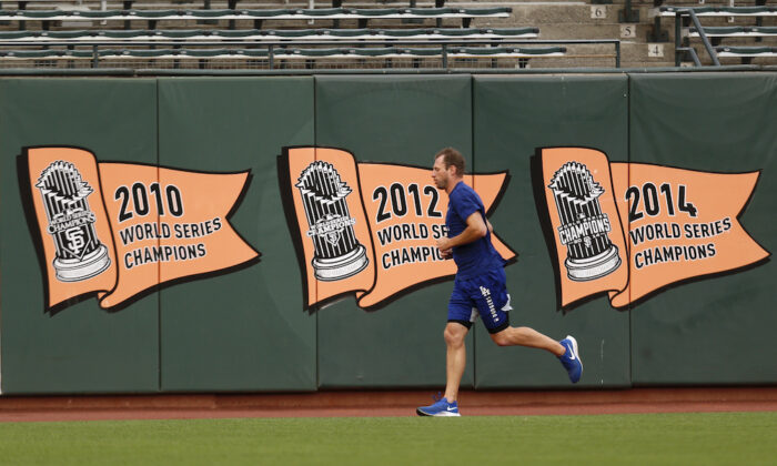 Los Angeles Dodgers' Max Scherzer runs in the outfield during a workout on Oct. 7, 2021, in San Francisco for the baseball team's National League Division Series against the San Francisco Giants, which starts Friday. (AP Photo/Jed Jacobsohn)