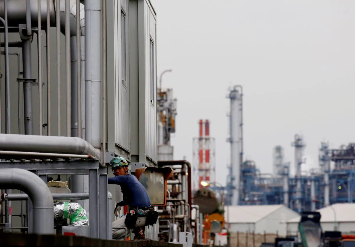 A worker is seen in front of facilities and chimneys of factories at the Keihin Industrial Zone in Kawasaki, Japan on Sept. 12, 2018. (Kim Kyung-Hoon/Reuters)