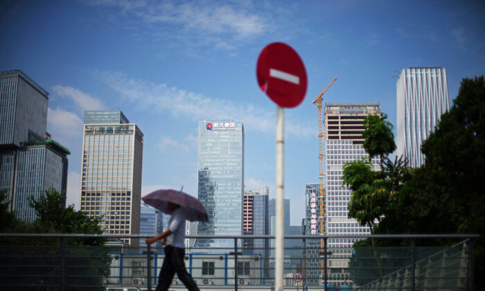 A man walks past a 'No Entry' traffic sign near the headquarters of China's Evergrande Group in Shenzhen, Guangdong Province, in China on Sept. 26, 2021. (Aly Song/Reuters)