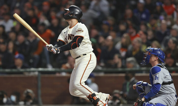 San Francisco Giants’ Buster Posey, left, watches his two-run home run in front of Los Angeles Dodgers catcher Will Smith during the first inning of Game 1 of a baseball National League Division Series Friday, Oct. 8, 2021, in San Francisco. (John Hefti/AP Photo)