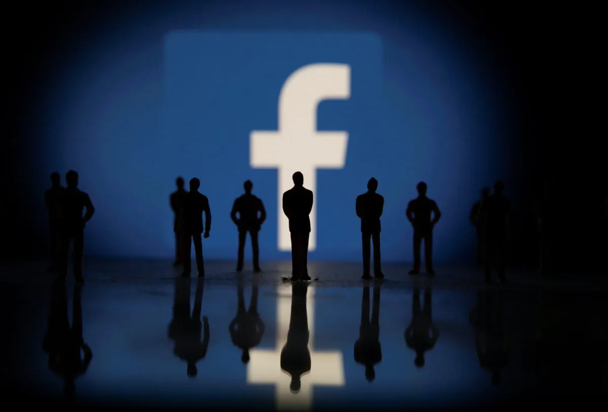Small toy figures are seen in front of displayed Facebook logo in this illustration taken on Oct. 4, 2021. (Dado Ruvic/Reuters)