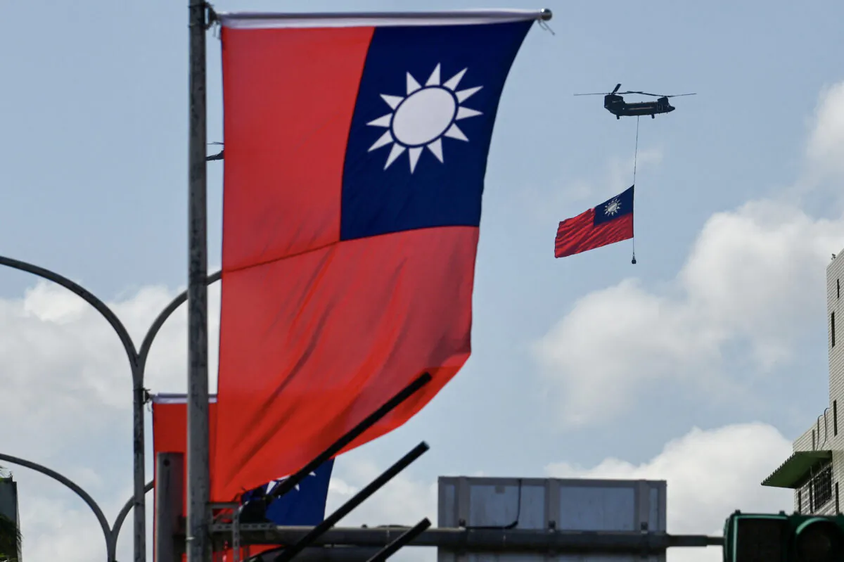 A CH-47 Chinook helicopter carries a Taiwan flag during national day celebrations in Taipei, Taiwan, on Oct. 10, 2021. (Sam Yeh/AFP via Getty Images)