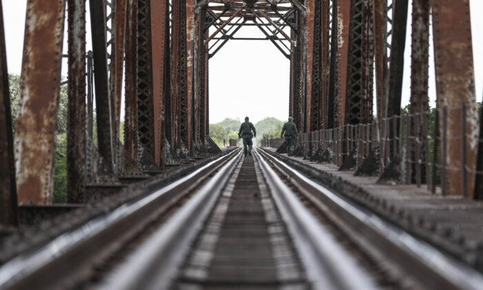 Border Patrol agents look for illegal aliens around a riverbed from a railway bridge near Uvalde, Texas, on Aug. 25, 2021. (Charlotte Cuthbertson/The Epoch Times)