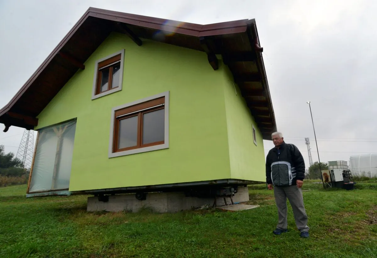 Vojin Kusic's stands in front of his rotating house, built and designed by 72-year-old Vojin Kusic, to satisfy his wife's shifting desires as to what she should see when she looks out of the windows of her home in a town of Srbac, northern Bosnia, on Oct. 10, 2021. (Radivoje Pavicic/AP Photo)