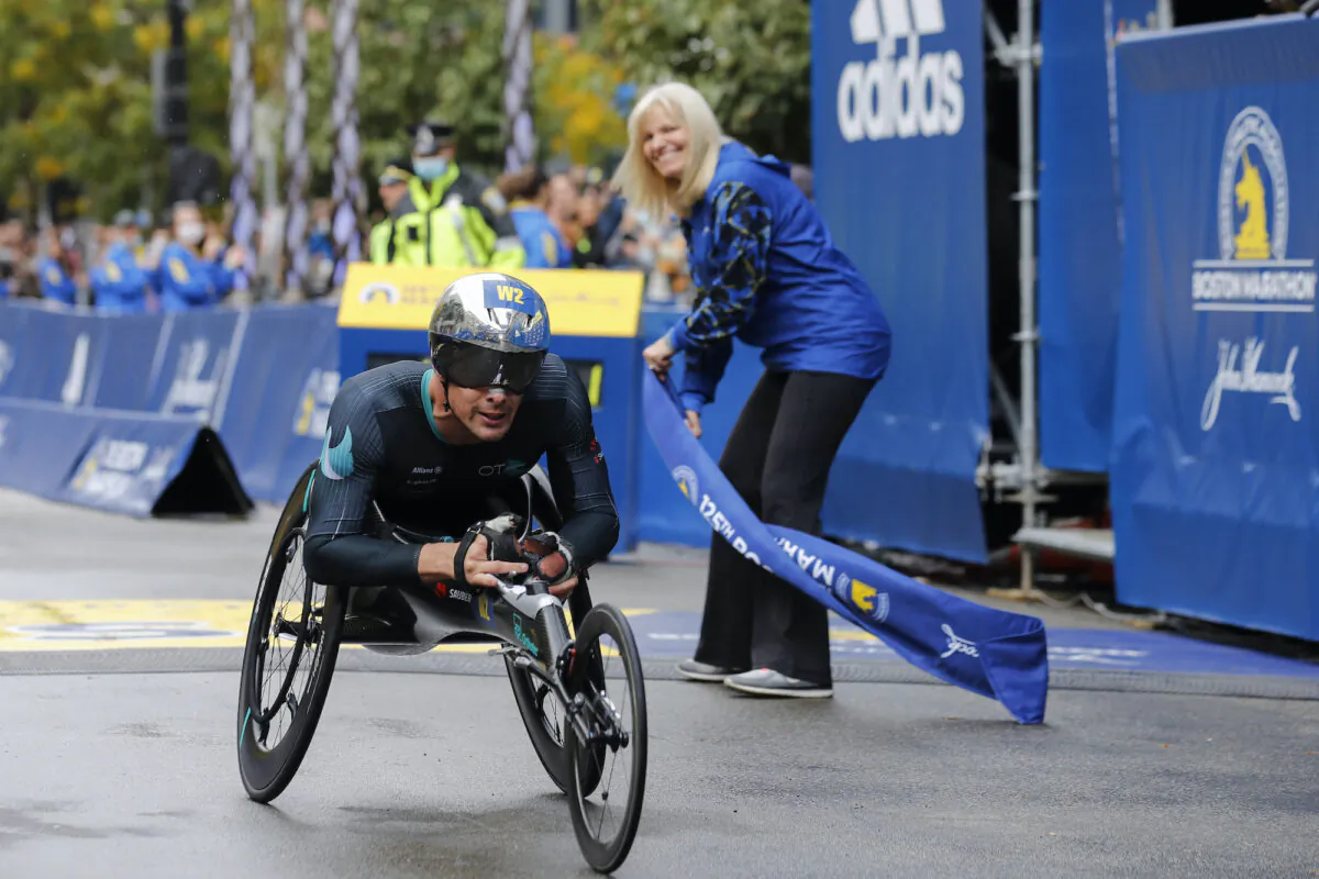 Marcel Hug, of Switzerland, crosses the finish line to win the men's wheelchair division of the 125th Boston Marathon on Oct. 11, 2021. (Winslow Townson/AP Photo)