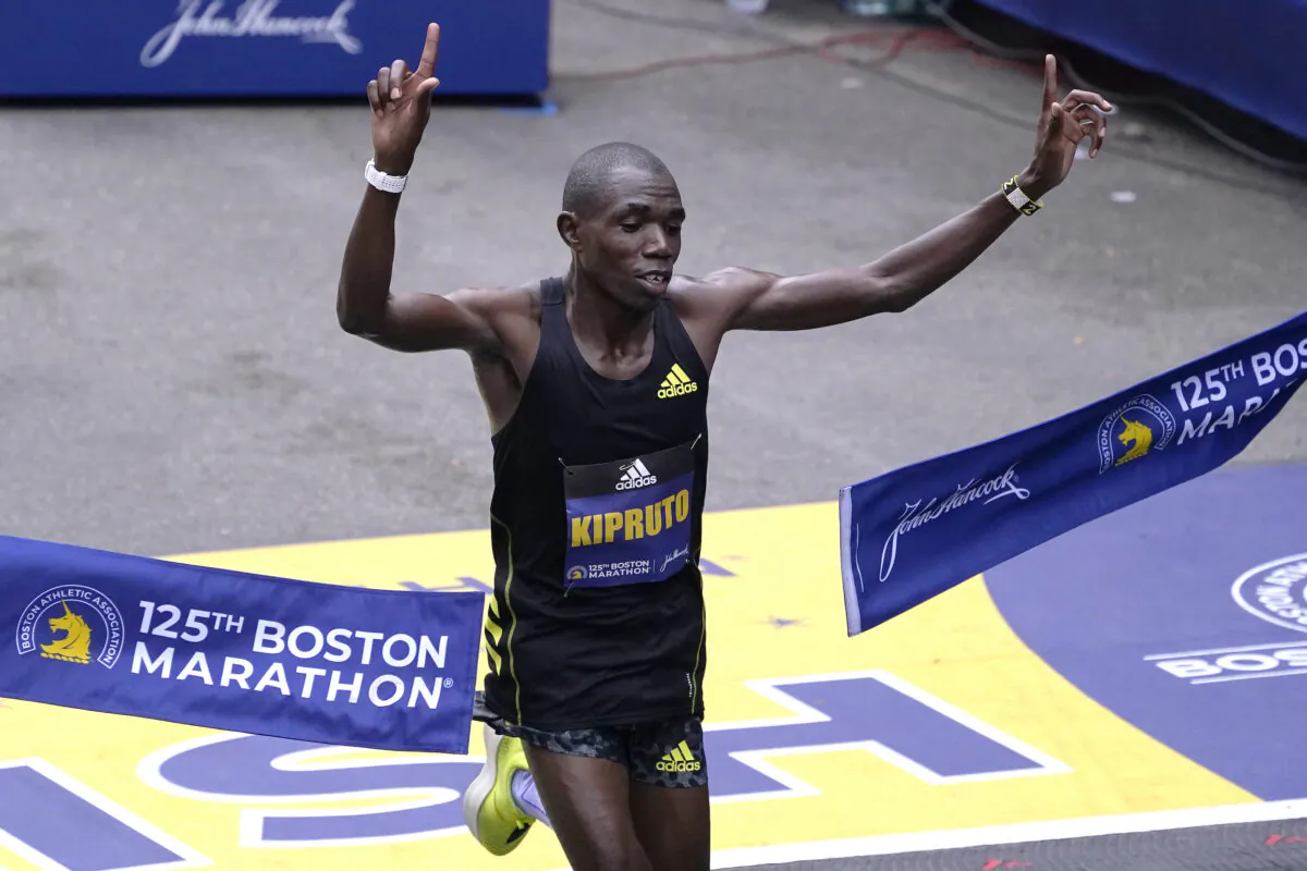 Benson Kipruto of Ethiopia breaks the finish line tape to win the Boston Marathon in Boston on Oct. 11, 2021. (Charles Krupa/AP Photo)