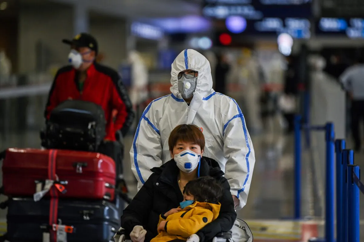 Passengers wearing masks arrive at Shanghai Pudong International Airport in Shanghai on March 19, 2020. (Hector Retamal/AFP via Getty Images)