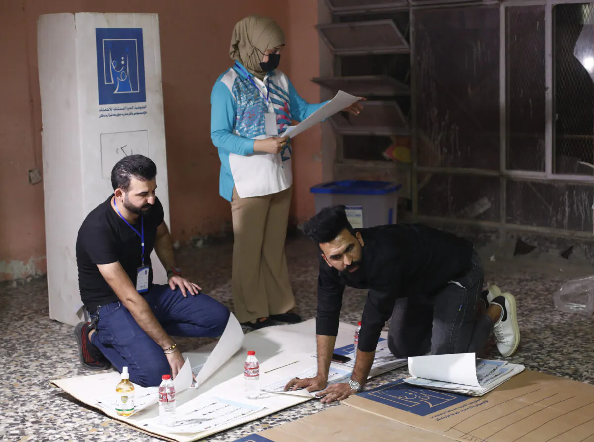 Election workers count ballots as they close a polling station at the end of voting in parliamentary elections, in Baghdad, Iraq, on Oct. 10, 2021. (Hadi Mizban/AP Photo)   