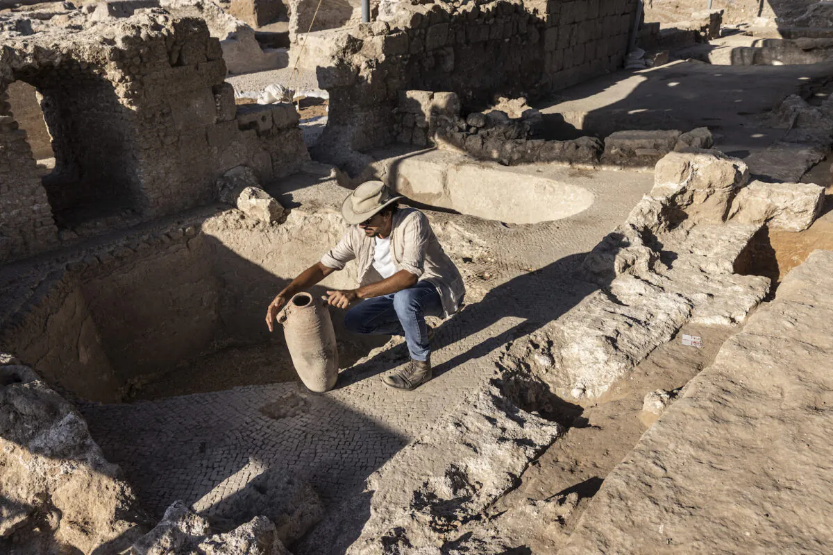 Avshalom Davidesko from the Israel's Antiquities Authority examines a jar in a massive ancient winemaking complex dating back some 1,500 years in Yavne, south of Tel Aviv, Israel, on Oct. 11, 2021. (Tsafrir Abayov/AP Photo)