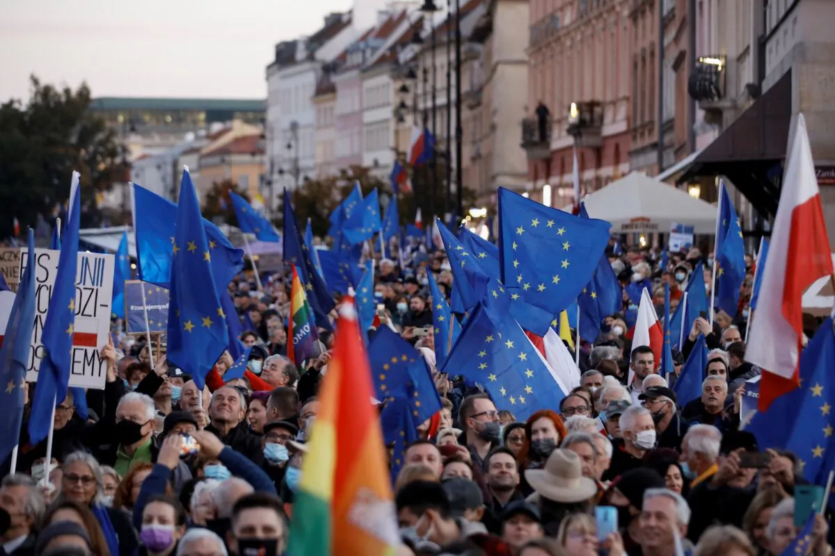 People carry flags, as they take part in a rally in support of Poland's membership in the European Union after the country's Constitutional Tribunal ruled on the primacy of the constitution over EU law, undermining a key tenet of European integration, in Warsaw, Poland, on Oct. 10, 2021. (Kacper Pempel/Reuters)