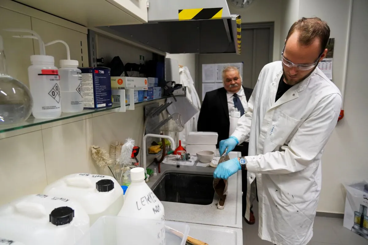 Tartu University's Professor Enn Lust and student Patrick Teppor work on carbon-based batteries using peat, in Tartu, Estonia, on Sept. 30, 2021. (Janis Laizans/Reuters)