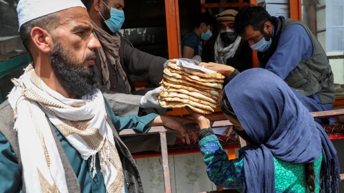 An Afghan girl receives free bread distributed by the government, outside a bakery, in Kabul, Afghanistan, on May 3, 2020. (Omar Sobhani/Reuters)