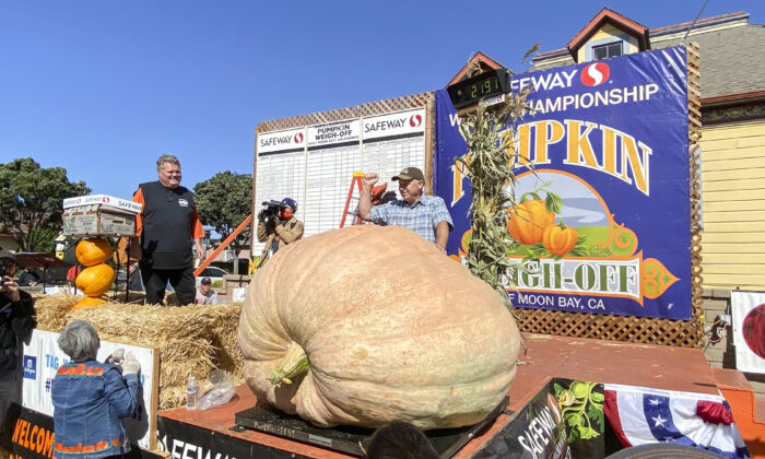 Jeff Uhlmeyer stands behind his 2,191-pound pumpkin, which won the 48th Safeway World Championship Pumpkin Weigh-Off in Half Moon Bay, Calif., on Oct. 11, 2021. (Ilene Eng/  Pezou)