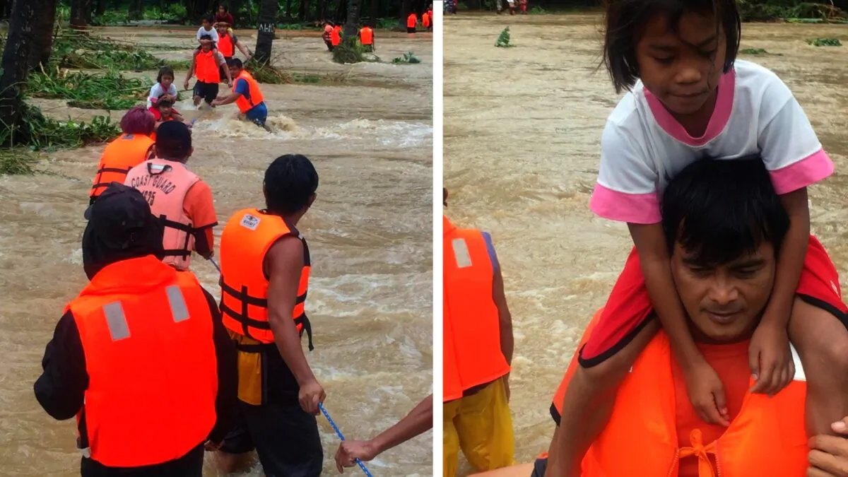 People cross floodwaters caused by tropical cyclone Kompasu during an evacuation assisted by the Philippine Coast Guard (PCG) at Brooke's Point, Palawan, in the Philippines, on Oct. 12, 2021. (Philippine Coast Guard via Reuters)