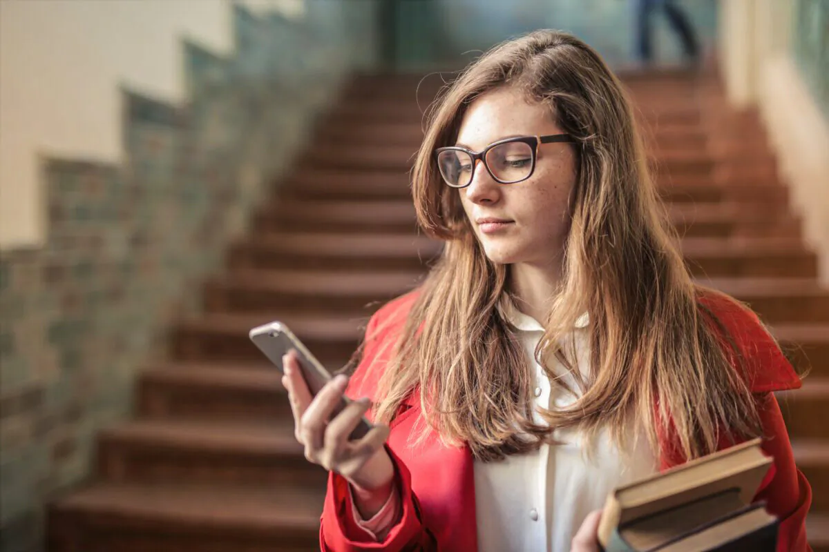 A woman looks at her phone. (Andrea Piacquadio/Pexels)