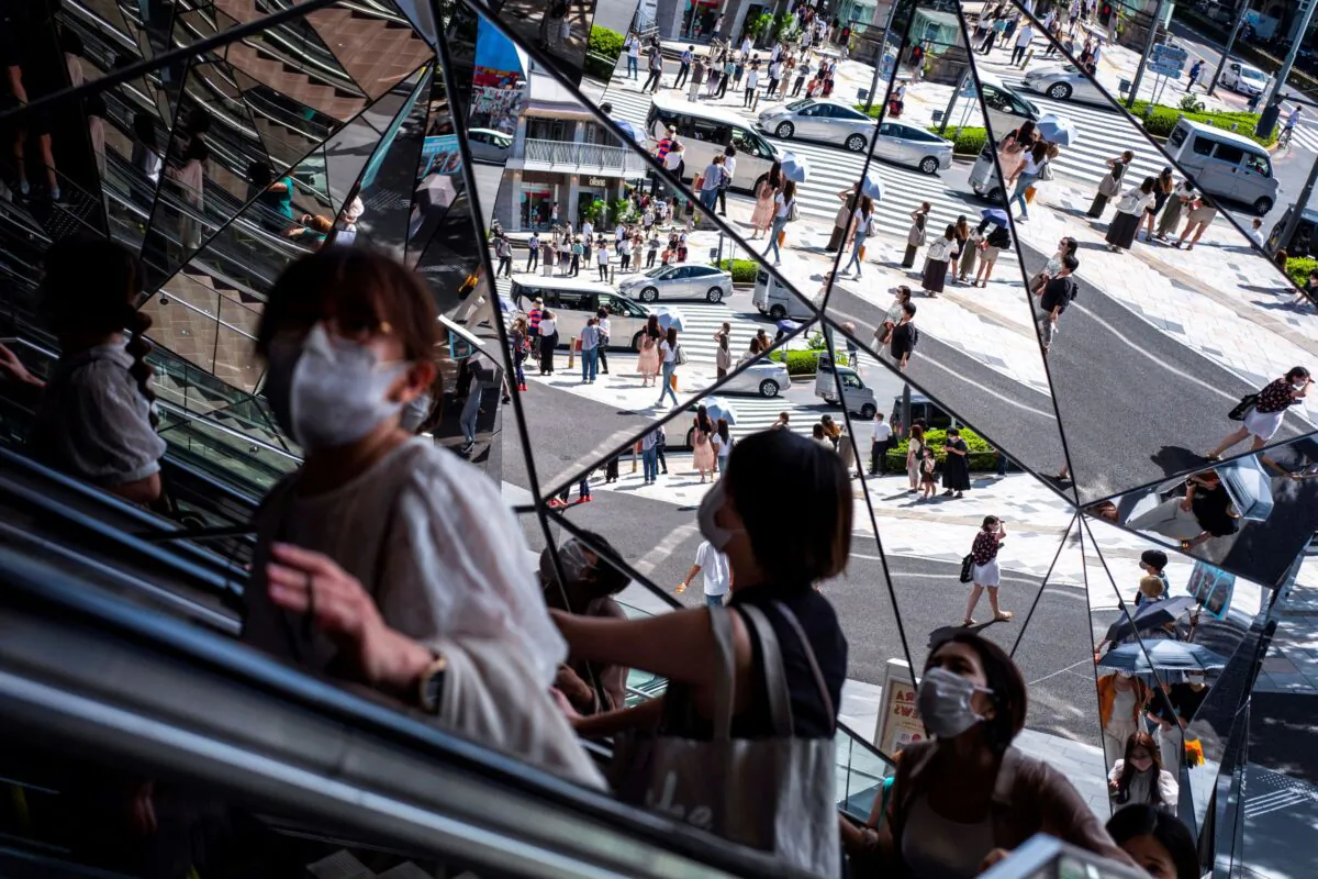 People wearing protective masks are reflected in the mirror at a shopping mall in Tokyo amid the coronavirus disease outbreak in Tokyo, Japan on Aug. 19, 2021. (Athit Perawongmetha/Reuters)