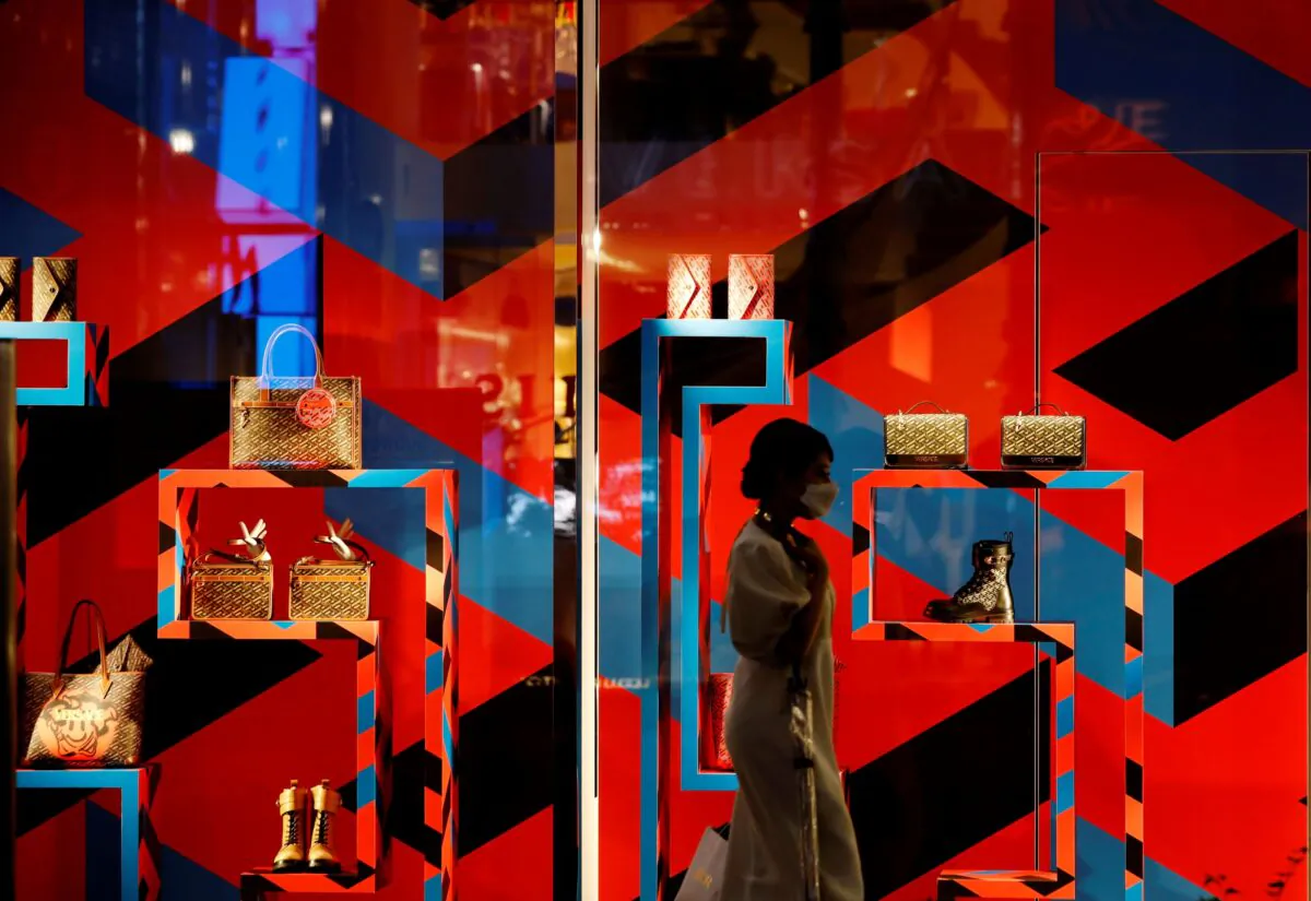 A woman wearing a protective mask, amid the CCP virus outbreak, walks past a luxury retail store at Ginza shopping district in Tokyo on Oct. 7, 2021. (Kim Kyung-Hoon/Reuters)