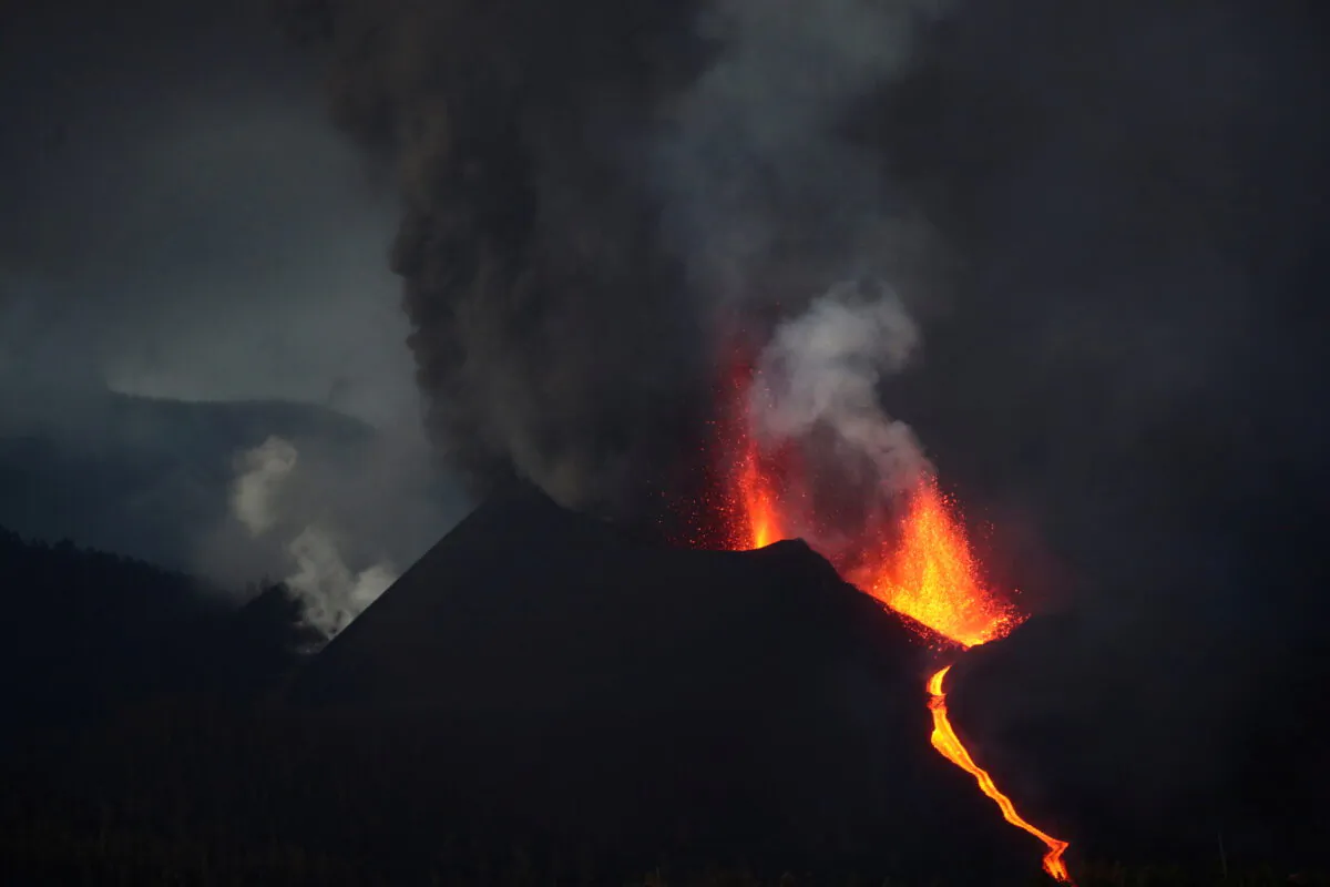 The Cumbre Vieja volcano spews lava and smoke as it continues to erupt on the Canary Island of La Palma, as seen from Tacande, Spain, on Oct. 12, 2021. (Sergio Perez/Reuters)